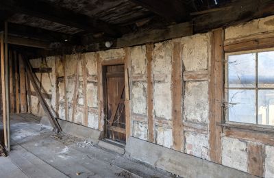 ansicht der südlichen Außenwand des Anbaus von 1655. Die Gefache sind mit hauptsächlich mit Bruchsteinen ausgemauert, teilweise aber auch mit Astgeflecht und Lehm ausgefüllt. (Foto: Christian Braunersreuther, 2025)