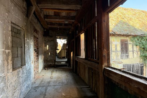 Laubengang am Nebengebäude mit Scheune rechts im Bild